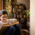 Niña con gafas graduadas leyendo junto a la ventana, control de miopía infantil con Stellest 2.0 en Manises